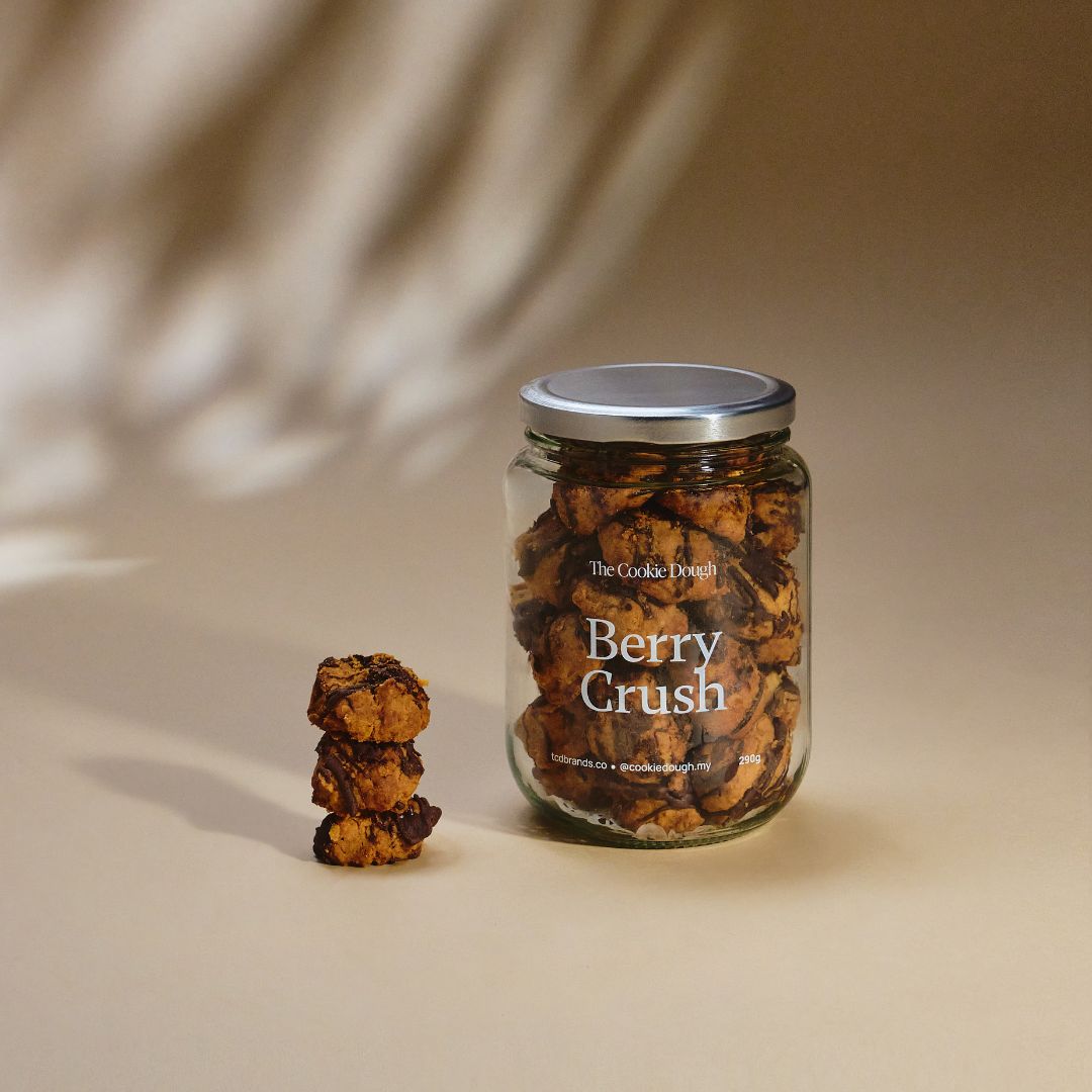 Jar of 'Berry Crush' cookies with a smaller stack of cookies on a beige background