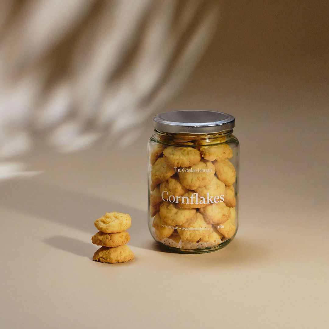 Jar of The Cookie Dough "Cornflakes" cookies on a beige background